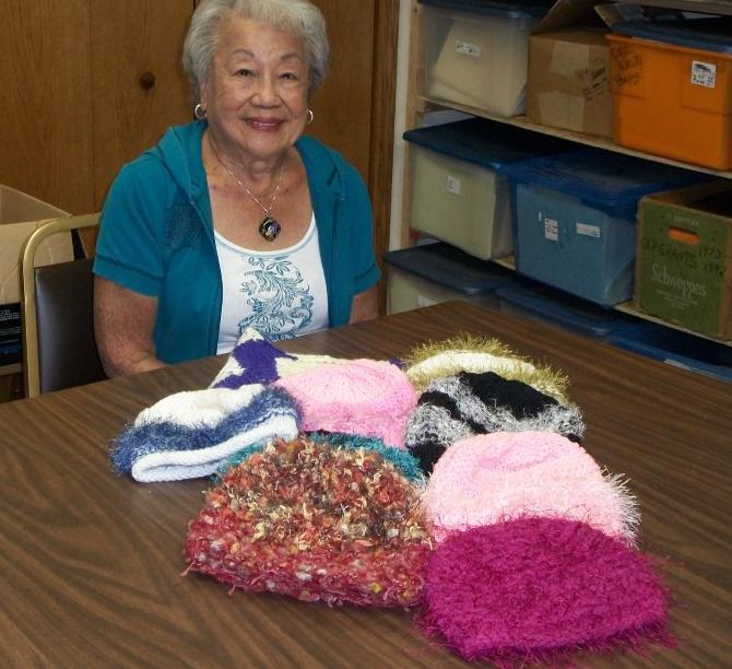 One of our home-based volunteers, Fung Scholz, with completed hats to be distributed this fall. 